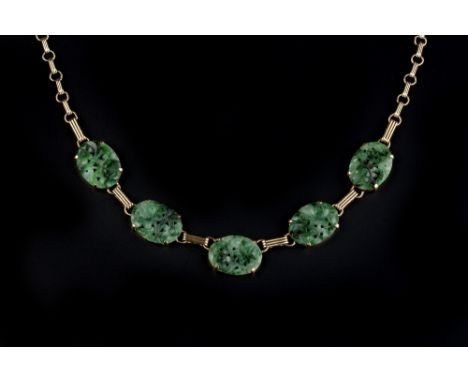 A JADE PANEL NECKLACE, comprising five oval jade panels of pierced and carved floral design, with reeded links between, the c