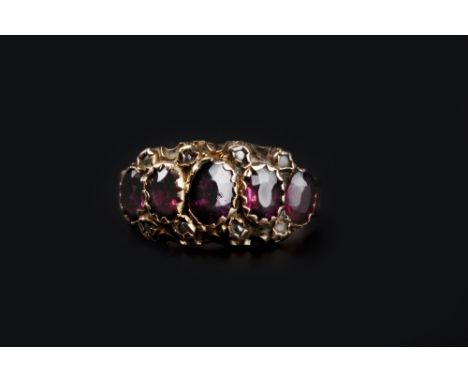 A VICTORIAN GARNET FIVE STONE RING, set with graduated oval mixed-cut garnets, between engraved tapered shoulders, ring size 