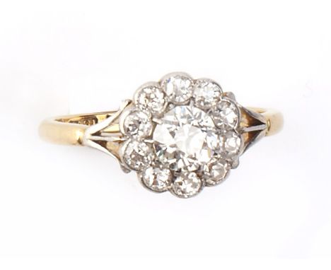 A DIAMOND CLUSTER RING, the principal old-cut diamond claw set within a border of old and single-cut diamonds, between trifur