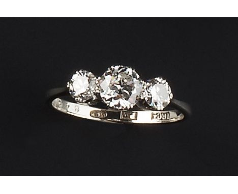 A DIAMOND THREE STONE RING, claw set with graduated round brilliant-cut diamonds, the white precious metal mount stamped '18c