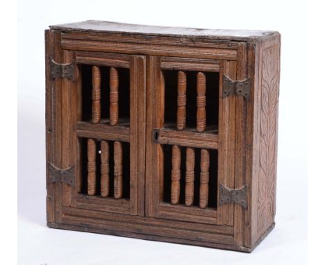 AN ANTIQUE OAK FOOD HUTCH with one shelf enclosed by two doors with ring turned slats and metal hinges, 63cm wide x 58cm high