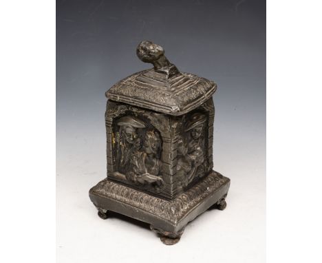 AN ANTIQUE HEAVY LEAD TEA CADDY with loose cover and figure decoration, 20cm high