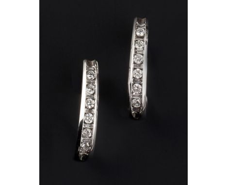 A PAIR OF DIAMOND SET EARRINGS, each half hoop channel set with a line of alternate round brilliant and baguette-cut diamonds