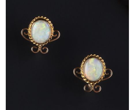 A PAIR OF OPAL EARRINGS, each oval cabochon opal collet set to a ropetwist wirework and scroll decorated mount, on screw fitt