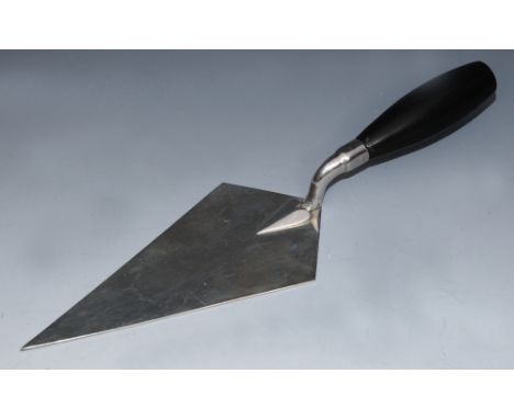 A SILVER PRESENTATION BRICKLAYERS TROWEL of plain form with a turned ebonised handle, 28cm long, Birmingham 1931 by Deakin & 