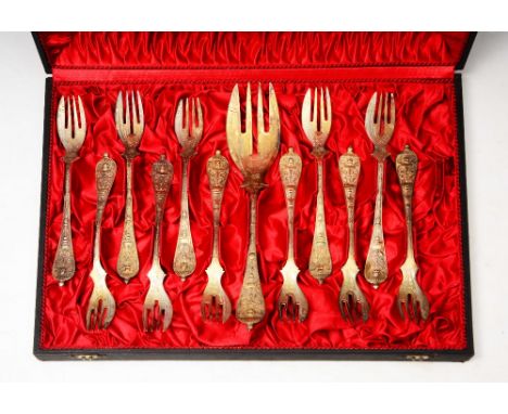 A CASED SET OF ELEVEN CONTINENTAL SILVER TEA FORKS with cherub and scroll decorated handles and one serving fork, 14.5 troy o