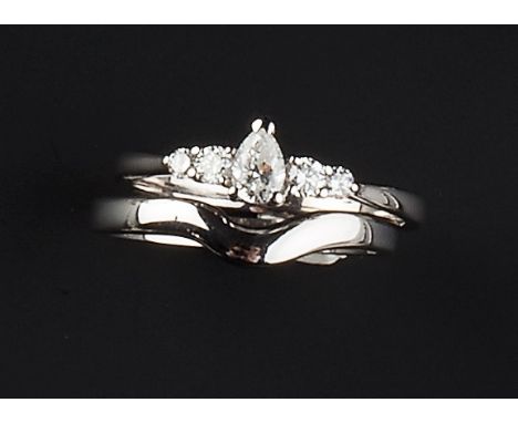 A DIAMOND FIVE STONE RING AND A WEDDING BAND, the first centred with a pear-shaped brilliant-cut diamond, between pairs of gr