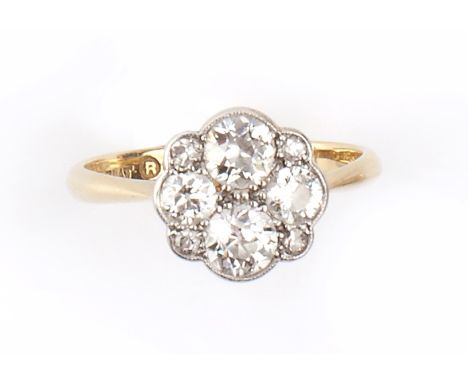 A DIAMOND PANEL RING, the shaped circular panel millegrain set with four old-cut diamonds, spaced by smaller single-cut diamo
