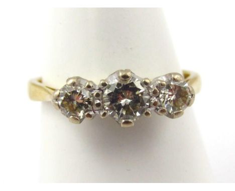 An 18ct gold three stone diamond ring, central round brilliant cut stone approx 0.39ct, in claw setting, flanked by two small