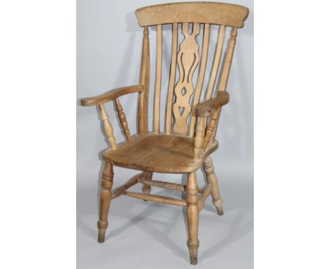 An early 20thC grandfather chair, with overhanging comb top, pierced inverted hour glass splat, shaped arms and ring turned f