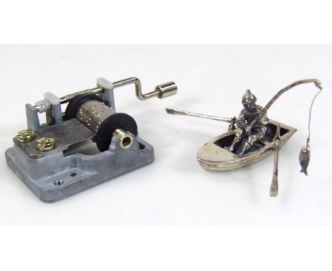 A miniature model of a Chinese fisherman in rowing boat, catching fish, white metal marked 925, 5cm wide, and a Yunsheng mini