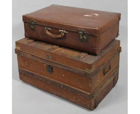 An early 20thC tin trunk, the rectangular top hinging to reveal a plain interior, on shaped base with side carrying handles, 