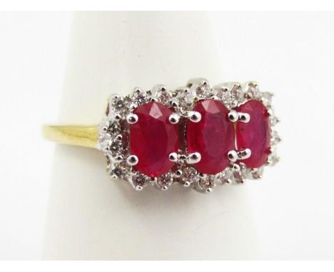 An 18ct diamond dress ring, claw set with three pink stones, on a part pierced shank, size M-N.