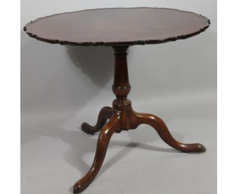 A late 18thC Chippendale design mahogany supper table, with one piece piecrust top, raised on baluster columns terminating in