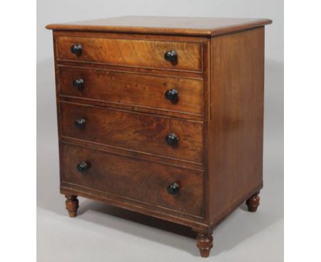 A George III mahogany commode chest, the rectangular moulded overhanging top articulating at the centre, on turned supports, 