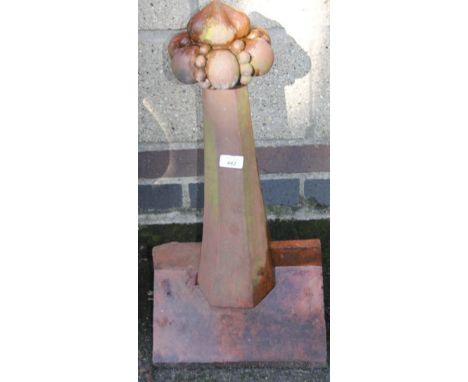 An elaborate redware ridge tile garden ornament, with shaped orb and flower head centre, on typical base, 66cm high, 36cm wid
