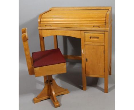 A mid 20thC child's light wood tambour single desk, with articulated lid revealing a one sectional writing section with drawe