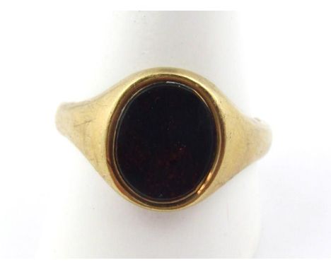 A gentleman's signet ring, centred by a central polished green stone, size Y, marks pitted.
