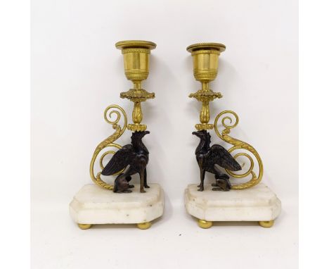 A pair of bronze and gilt metal candlesticks, stems in the form of griffins, on white marble bases, 18 cm highSconces very lo