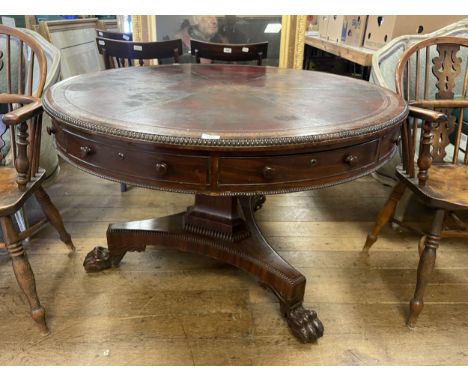 A 19th century mahogany drum table, with a gilt tooled leather top, with three real and three false drawers, on a carved supp