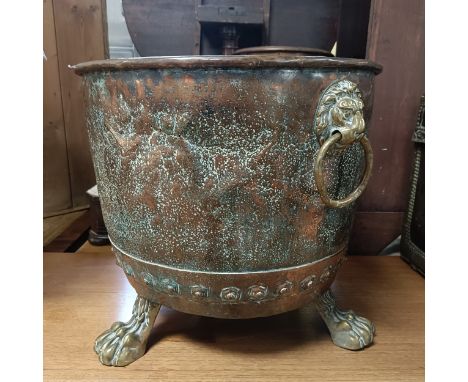 A copper and brass coal bin, with lion's head ring handles, on claw feet, 50 cm diameter