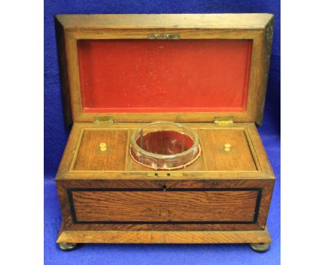 Late 19th/early 20th Century oak tea caddy revealing two lidded compartments and glass central bowl raised on four bun type f