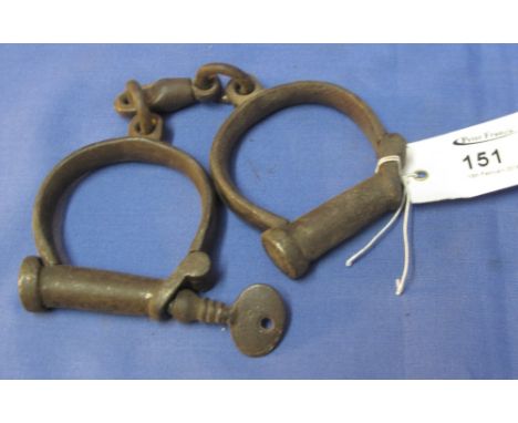 Pair of vintage metal handcuffs with key.