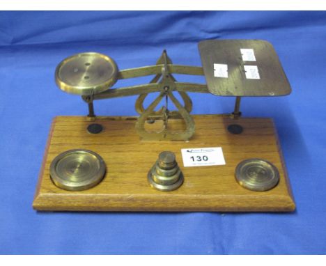 Set of gilt brass postal scales with weights on oak base.