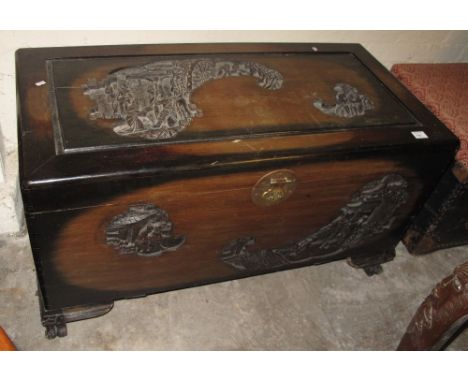 Camphor wood chest or trunk highly decorated with incised and carved Oriental scenes.
