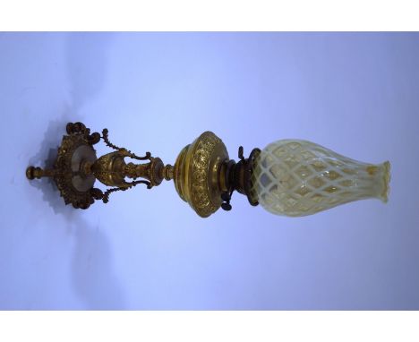 A Victorian oil lamp by Evered & Co Ltd, the gilt metal column and reservoir with classical detail, the pale green shade with
