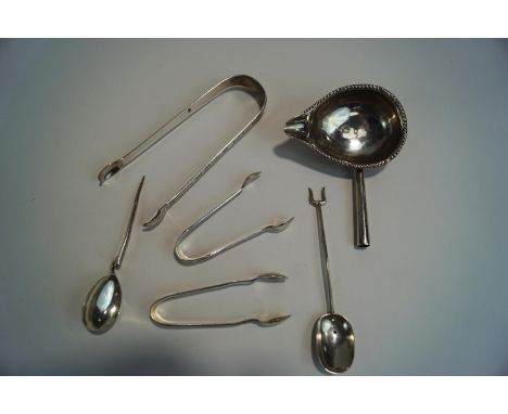 A pair of Georgian silver sugar tongs; two smaller later silver sugar tongs; a silver copy of a Roman spoon; a modern silver 