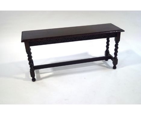 A late Victorian oak bench seat, with carved detail, barley twist legs united by a stretcher, 48cm high x 106cm wide x 33cm d
