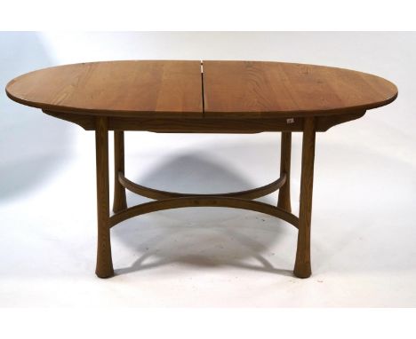 An Ercol extending beech and elm dining table, the turned and flared legs linked by semi-circular stretchers, 74cm high x 103