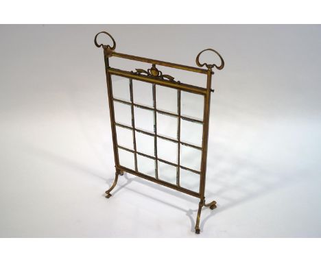 An Art Nouveau brass fire screen, with square glass panels, 80cm x 57cm
