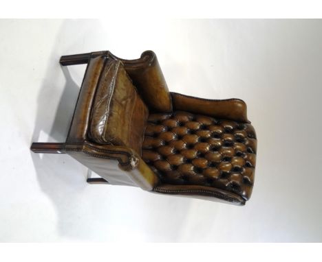 A 20th Century leather Chesterfield style armchair, with metal studding, tapestry cushion and antimacassars