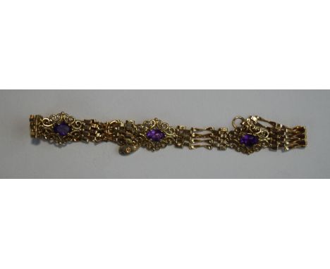 A 9 carat gold amethyst bracelet, the three scroll set motifs to gate links, with a padlock clasp, 7.9 g gross, 17 cm long
