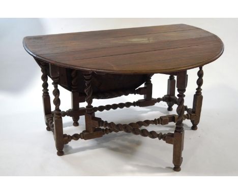 A mahogany gate leg table, the oval top on barley twist legs, 78cm high x 142cm wide