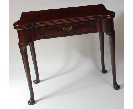 An early George III mahogany card table, the fold-over top having proud corners and dished counter wells, above a frieze draw
