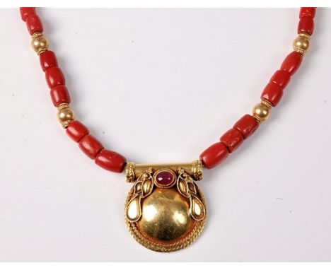 A coral and ruby necklace, the disc pendant, 23mm diameter, with beaded border and leaf shaped ornament, set with a single ru