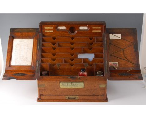 A Victorian oak and brass bound stationery box, the twin doors opening to reveal well-fitted tiered interior with letter-rack