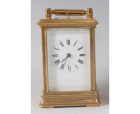 A circa 1900 brass carriage clock, having swing carry handle, visible platform escapement over a white enamel dial, twin barr