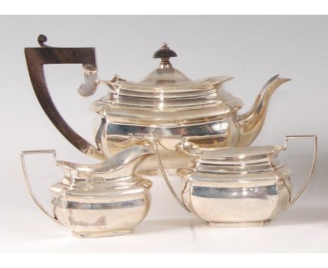 An Edwardian silver three-piece tea set, comprising teapot, twin handled sugar and cream, each of oval bombe form, 17oz, make