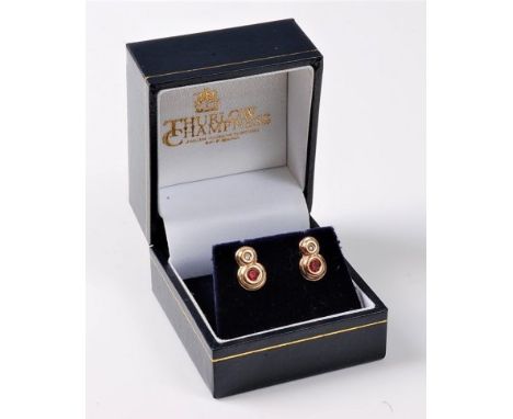 A pair of ruby and diamond earrings, the small round brilliant cut diamond set above a round ruby, both collet mounted in unm