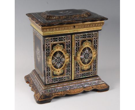 A Victorian papier-mâché and mother of pearl inlaid lady's needlework cabinet, the shaped hinged cover opening to reveal silk