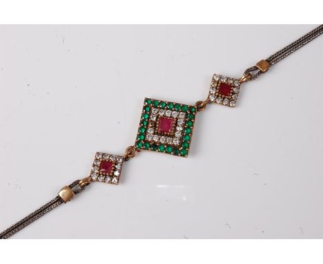 An Eastern style multi gemset bracelet, the central square panel set with a square ruby surrounded by small white hardstones 