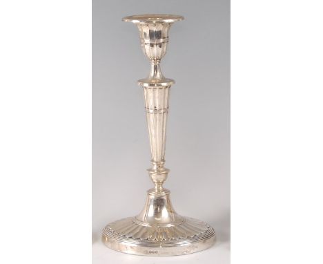 A silver candlestick, in the Adam style, having detachable sconce, oval tapering fluted and knopped column to a loaded base, 