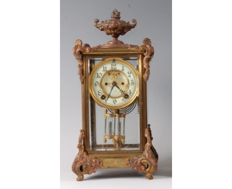 A late 19th century gilt brass four glass mantel clock , the case surmounted with a pedestal urn, the white enamel dial havin