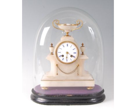 A late Victorian alabaster and gilt metal mantel clock under glass dome, the clock surmounted with a pedestal bowl over white