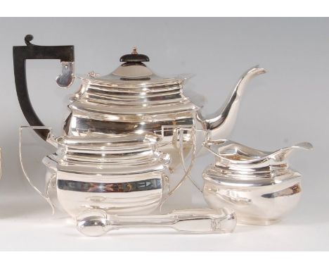 An Edwardian silver three-piece tea set, comprising teapot, twin handled sugar and cream, each of rectangular bombe form, the