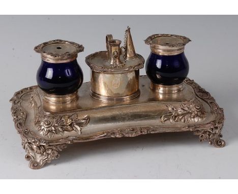 A William IV silver desk stand, having central detachable chamberstick with conical snuffer flanking twin silver topped blue 